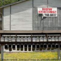 A building with multiple mailboxes and a 'for rent' sign