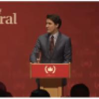 Canada's Prime Minister Trudeau standing at a dias emblazoned with a communist symbol